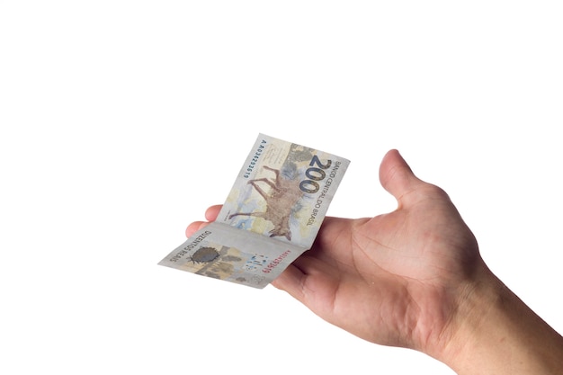 Homem segurando notas de 200 reais isoladas no branco. Dinheiro brasileiro. pagando.