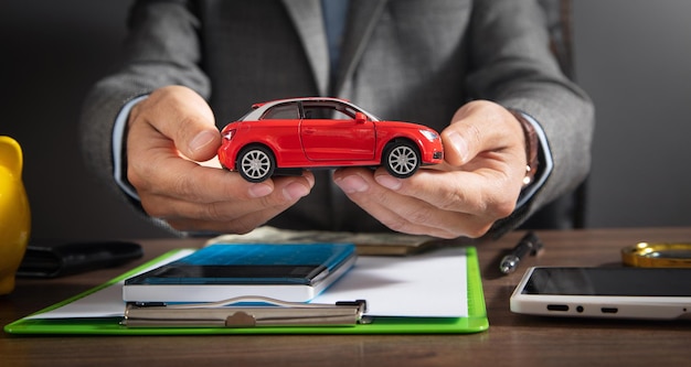 Homem segurando o carro de brinquedo vermelho