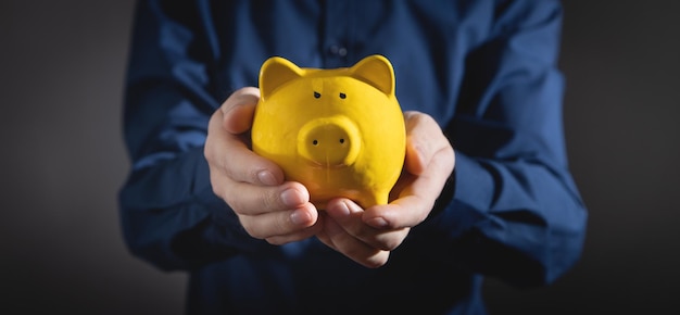 Homem segurando o cofrinho Investimento de negócios