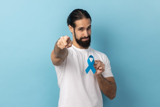 Homem segurando o símbolo de doença de consciência azul apontando para o suporte da câmera