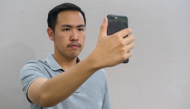 homem segurando o smartphone e usando tecnologia de reconhecimento de varredura de rosto para desbloquear e acesso