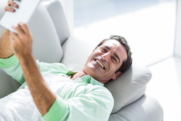 Homem segurando o tablet digital em casa