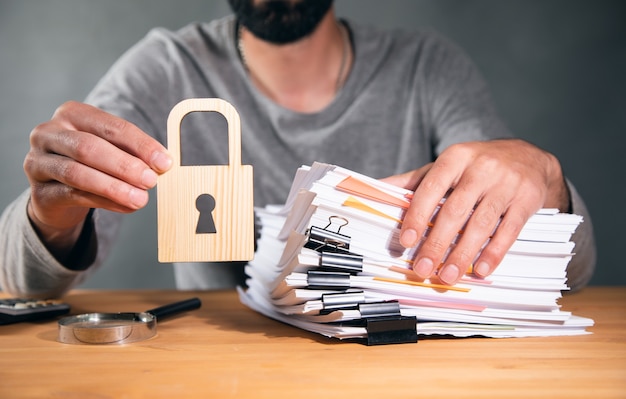 Foto homem segurando pilha de papel e cadeado