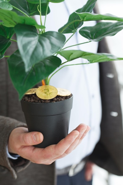 Foto homem segurando, planta da casa com moedas de bitcoin no chão.