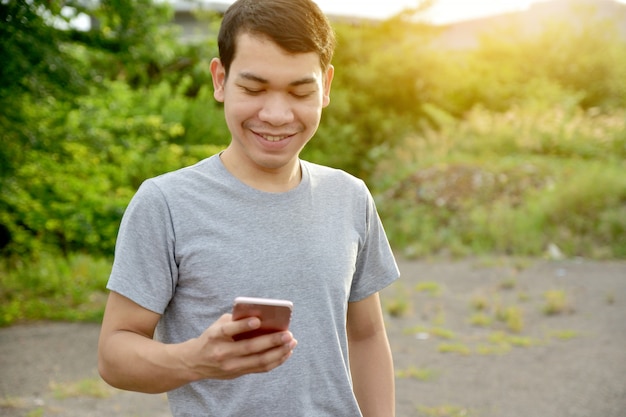 Homem, segurando, smartphone, e, sorrizo, homem, usando, telefone móvel