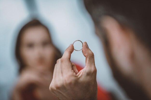 Foto homem segurando sua aliança de casamento após o divórcio