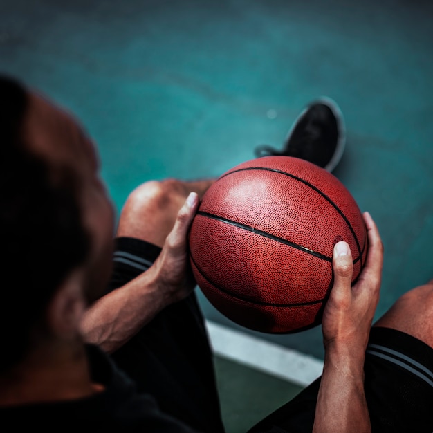 Foto homem segurando sua bola de basquete favorita