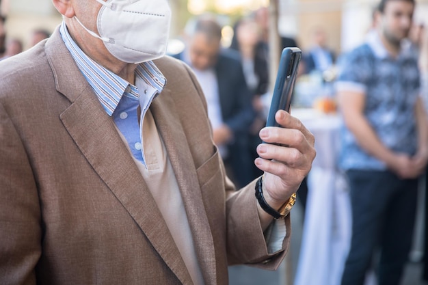 Foto homem segurando telefone com máscara médica