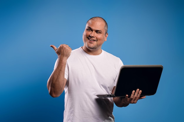 Foto homem segurando um caderno e apontando para o lado