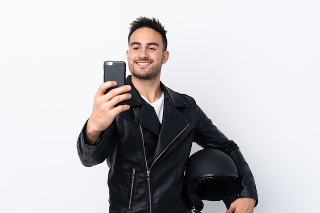 Homem segurando um capacete de moto sobre parede isolada