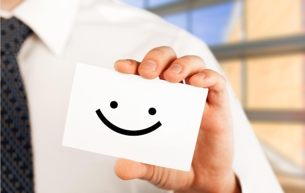Homem segurando um cartão de visita com smiley feliz