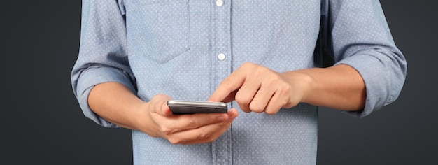 Homem segurando um dispositivo smartphone e tocando a tela