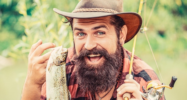 Homem segurando um peixe truta Pescador pescador com troféu de pesca Pescador e trutas Fundos de pesca Homem segura trutas grandes em suas mãos