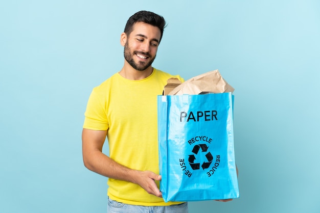 Homem segurando um saco de reciclagem cheio de papel