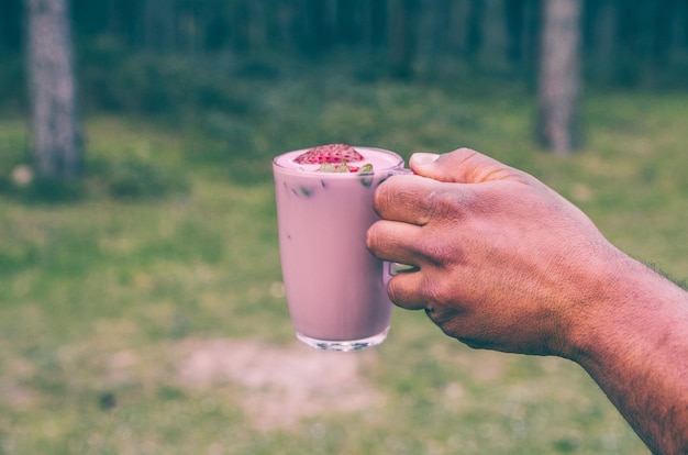 Homem, segurando, um, smoothie morango, em, natureza