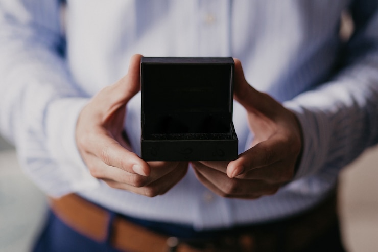 Foto homem segurando uma caixa de presente preta aberta