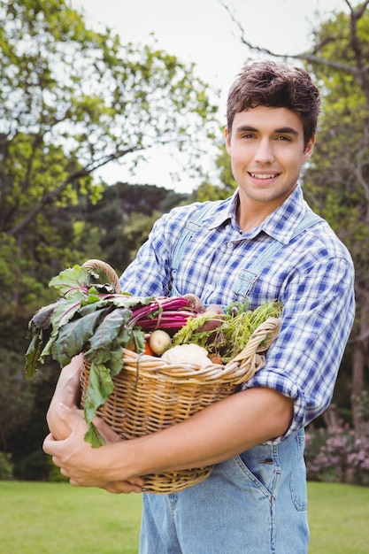 Foto homem segurando uma cesta de legumes recém-colhidos no jardim