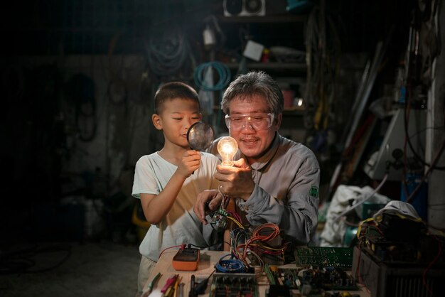 Foto homem segurando uma lâmpada com um menino na loja de trabalho