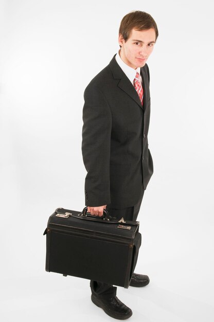 Foto homem segurando uma maleta enquanto está de pé contra um fundo branco