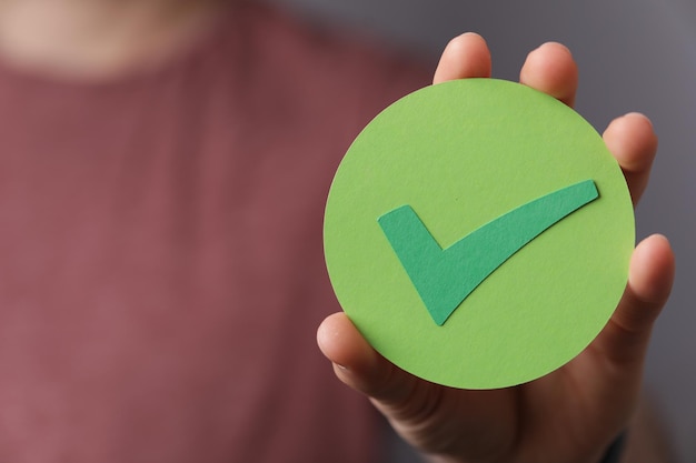 Homem segurando uma marca de verificação verde