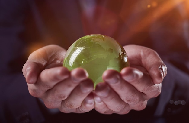 Homem segurando uma pequena bola de vidro verde generativa ai