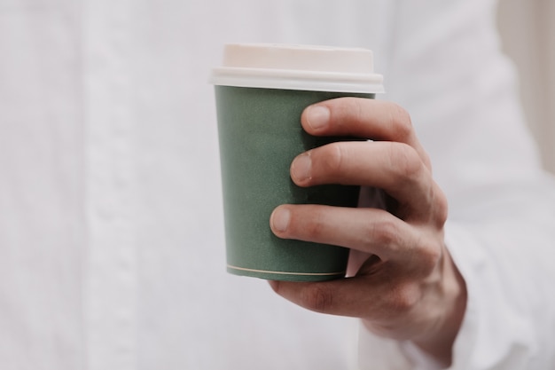 Foto homem segurando uma xícara de café.