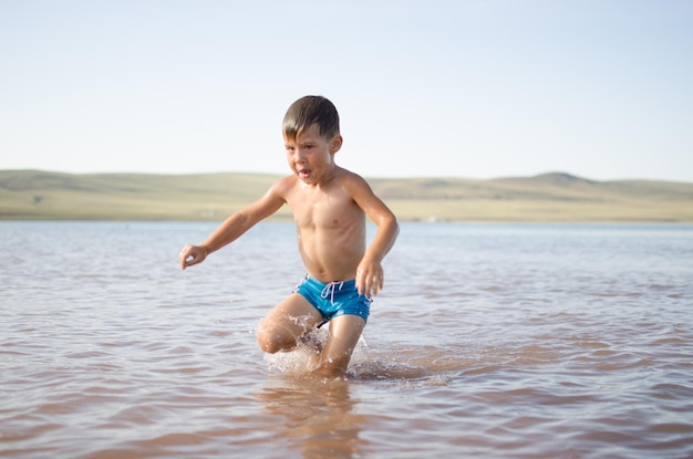 Homem sem camisa a brincar no mar.
