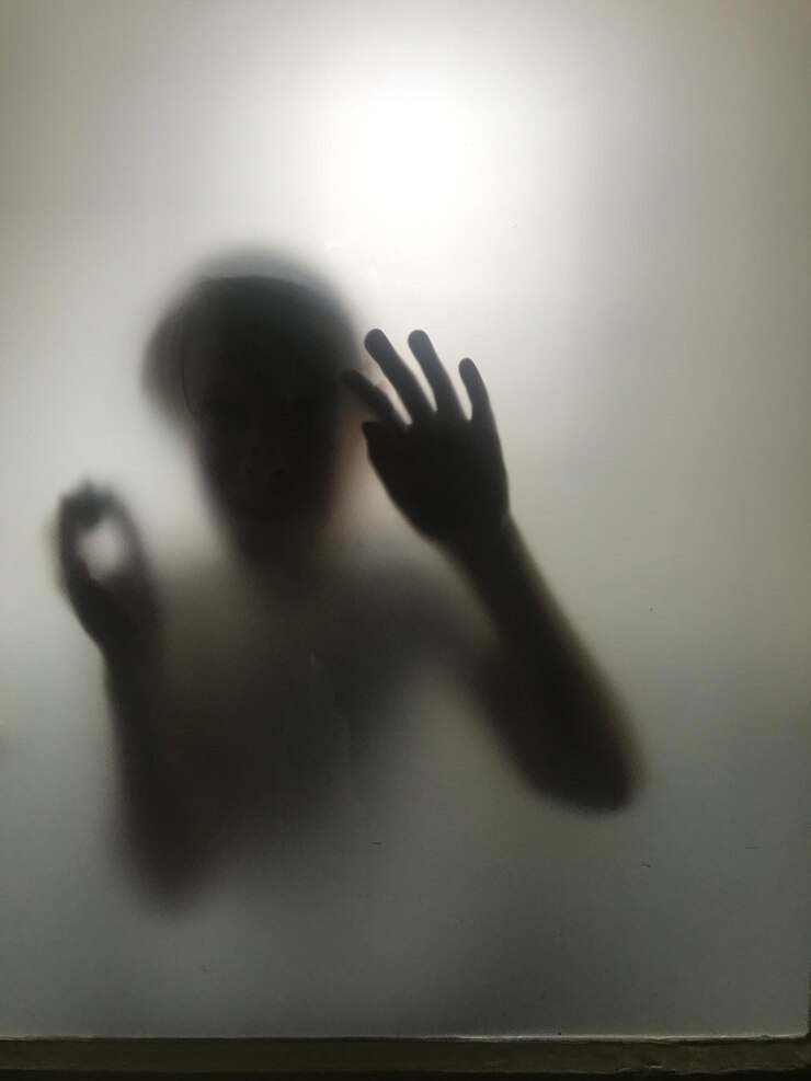 Foto homem sem camisa a espreitar através do vidro