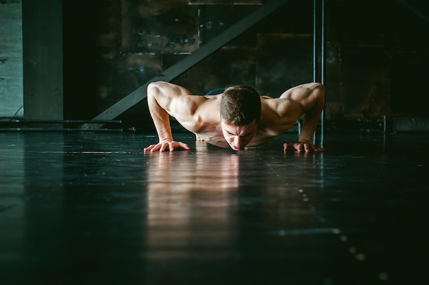 Homem sem camisa a exercitar-se no chão