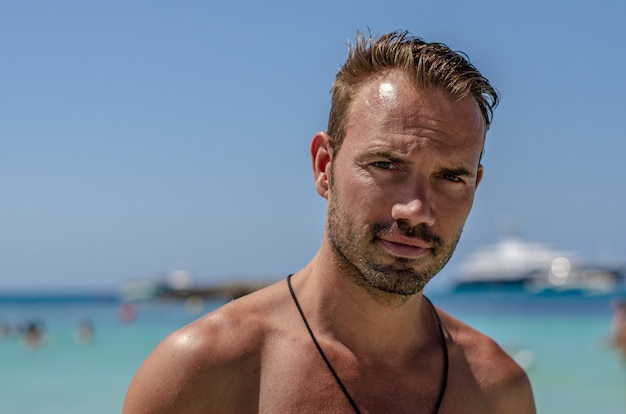 Homem sem camisa, aproveitando a praia