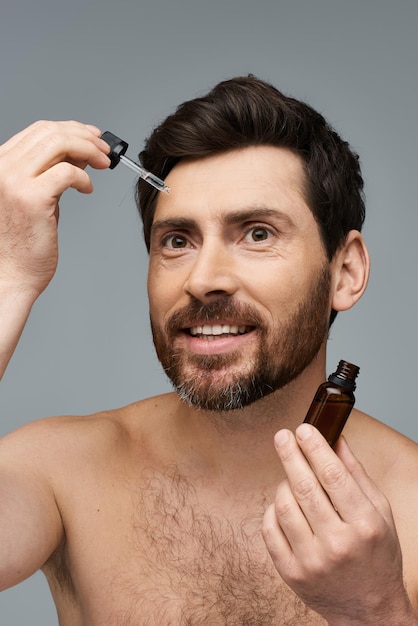 Homem sem camisa com garrafa de cabelo