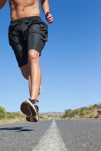 Homem sem camisa, correr na estrada aberta