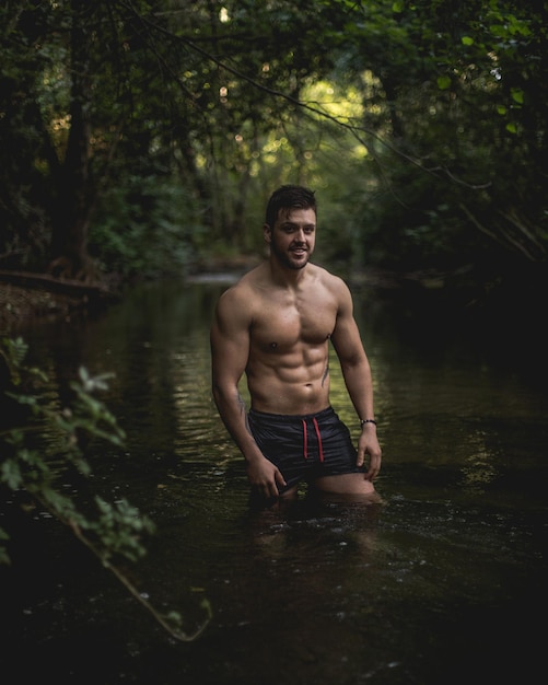 Foto homem sem camisa na floresta.