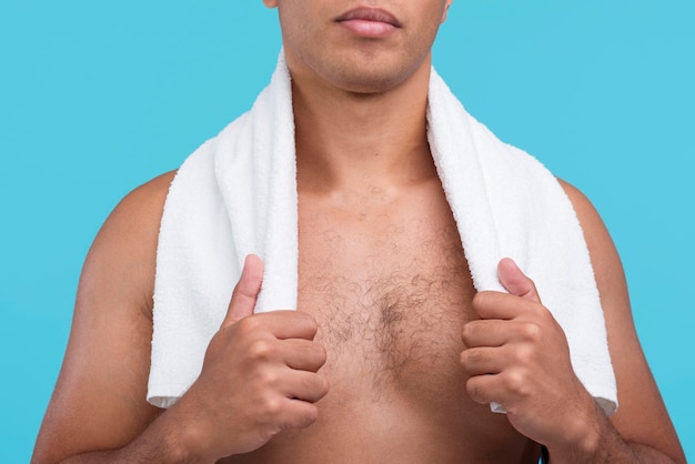 Foto homem sem camisa posando com uma toalha no pescoço