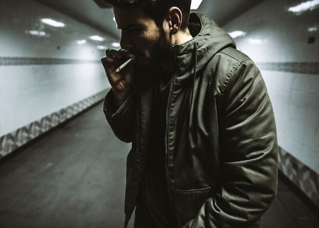 Homem sem-teto fumando vício de cigarro