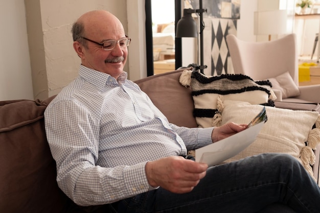 Homem sênior assistindo fotos de sua família sorrindo