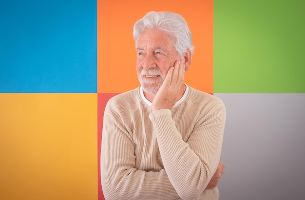 Homem sênior bonito adulto sorrindo em pé sobre fundo colorido bonito Caucasiano 70 anos homem barbudo de cabelos brancos posando para retrato Espaço de cópia