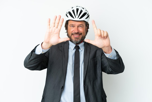 Homem sênior de negócios com um capacete de bicicleta isolado no fundo branco, contando sete com os dedos