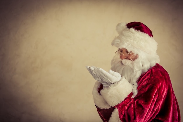 Homem sênior de papai noel contra o fundo do grunge. conceito de férias de natal