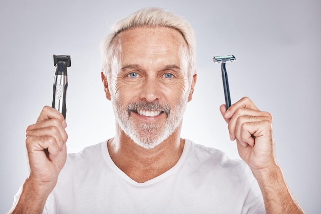 Homem sênior de retrato e navalha para cosméticos, beleza e cuidados com a pele em fundo de estúdio cinza Rosto homem maduro e idoso com sorriso de aparador elétrico e produtos de cabelo para penteado e feliz