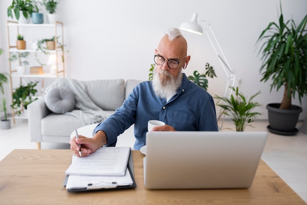 Homem sênior de tiro médio com laptop