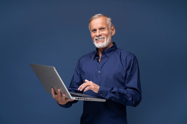 Foto homem sênior de tiro médio segurando laptop