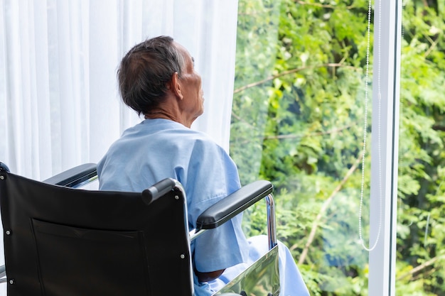 Homem sênior em sua cadeira de rodas com as costas no hospital.