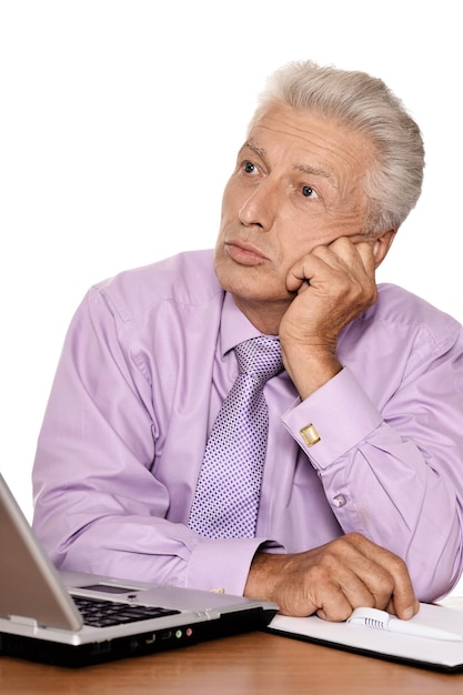 Homem sênior emocional com roupa formal usando laptop