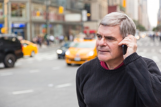 Homem sênior falando no celular em Nova York