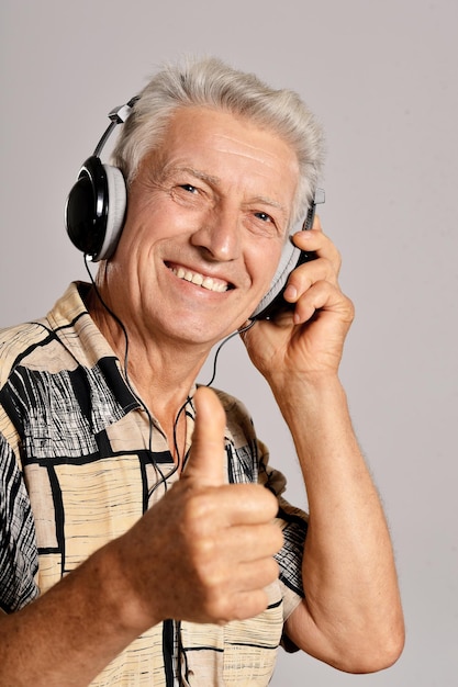 Homem sênior ouvindo música em fones de ouvido