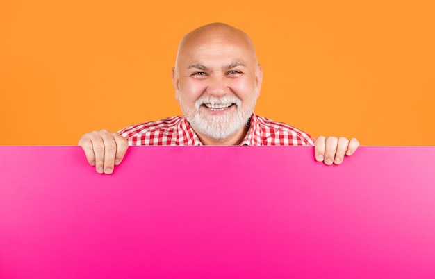 Foto homem sênior sorridente com espaço de cópia em banner em branco apresentando o produto