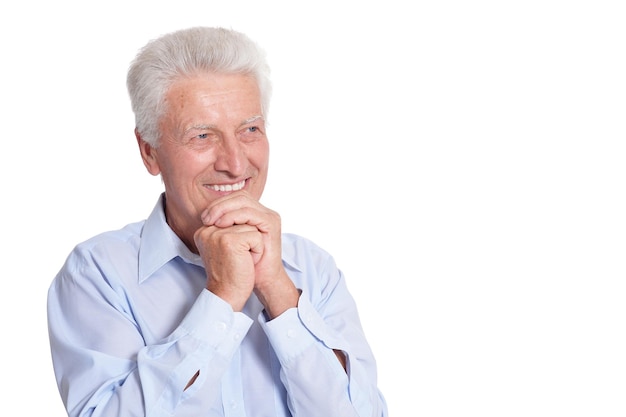 Homem sênior sorridente na camisa azul posando isolado no fundo branco