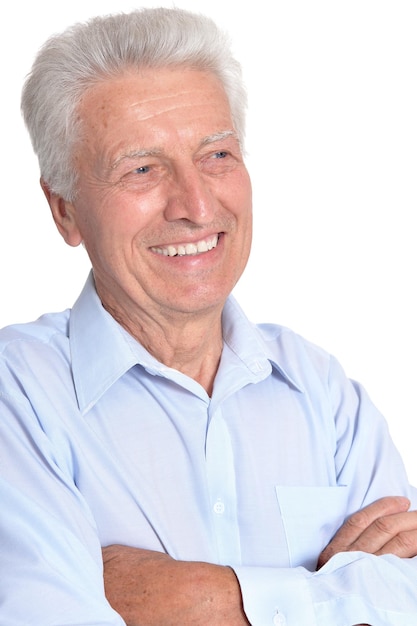 Homem sênior sorridente na camisa azul posando isolado no fundo branco