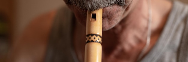 Homem sênior tocando flauta sem rosto masculino não profissional gravador caucasiano idosos pessoas com bigode com boca e lábios tocam no tubo música amadora close-up em casa hobbies e banner de lazer